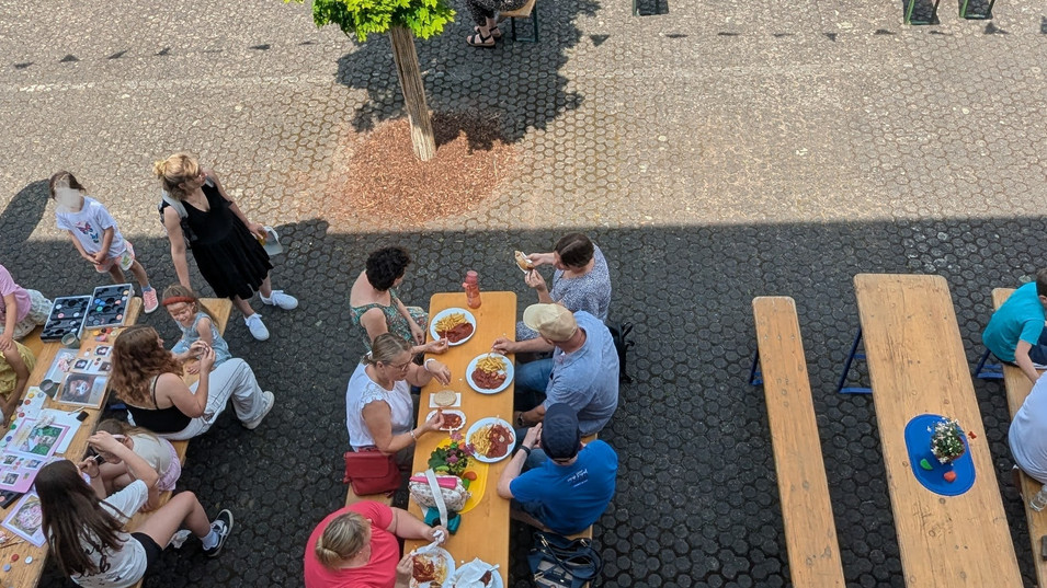 Blick von oben auf Gäste beim Essen und auf die Station Kinderschminken