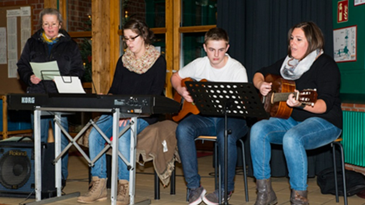 Schüler und Lehrkräfte musizieren. 