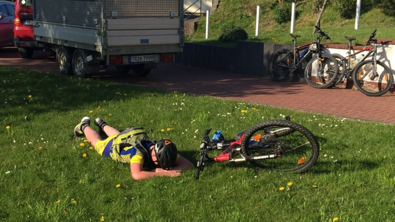 Schüler liegend auf Wiese.