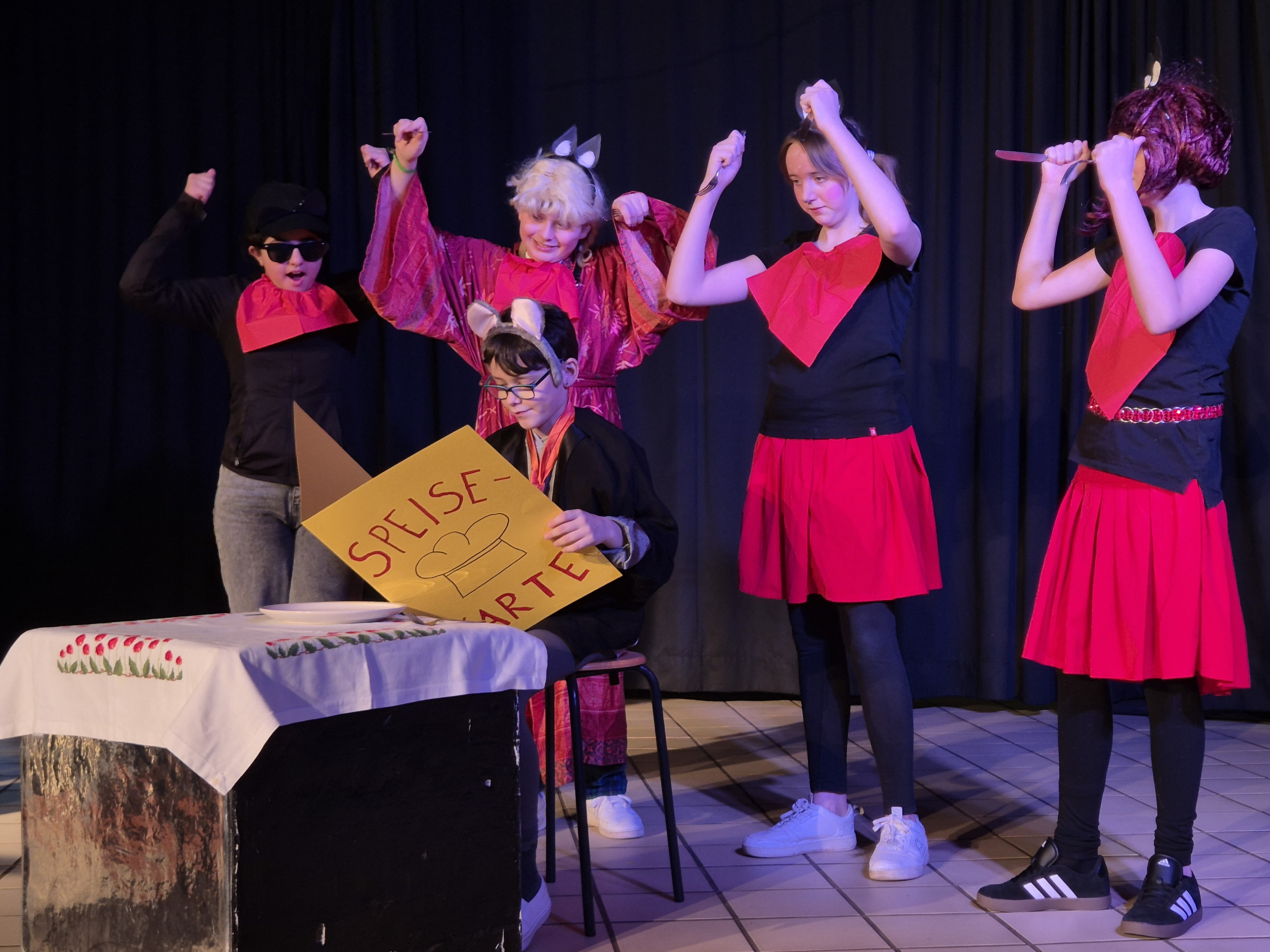 Schülerinnen und Schüler führen einen Sketch auf der Bühne auf.