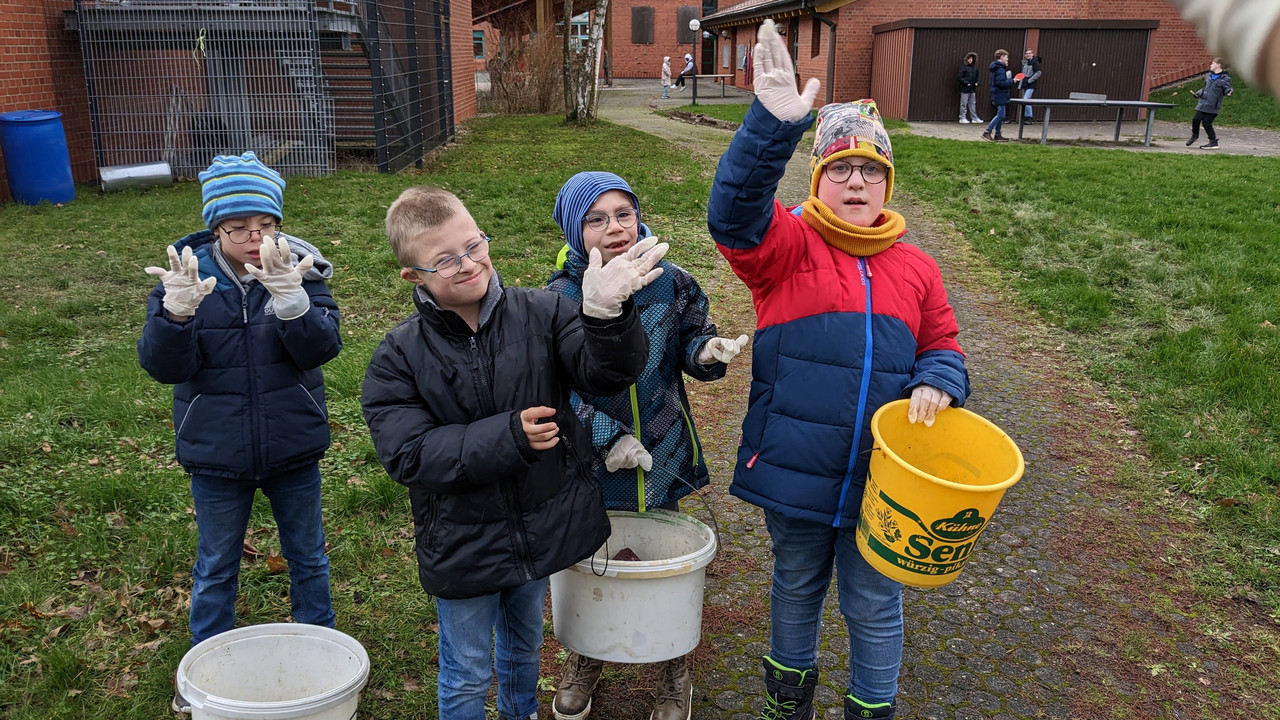Die GE U/M sorgt für Ordnung auf dem Schulgelände. Schüler*innen mit Eimern in der Hand sammeln Müll auf dem Schulgelände
