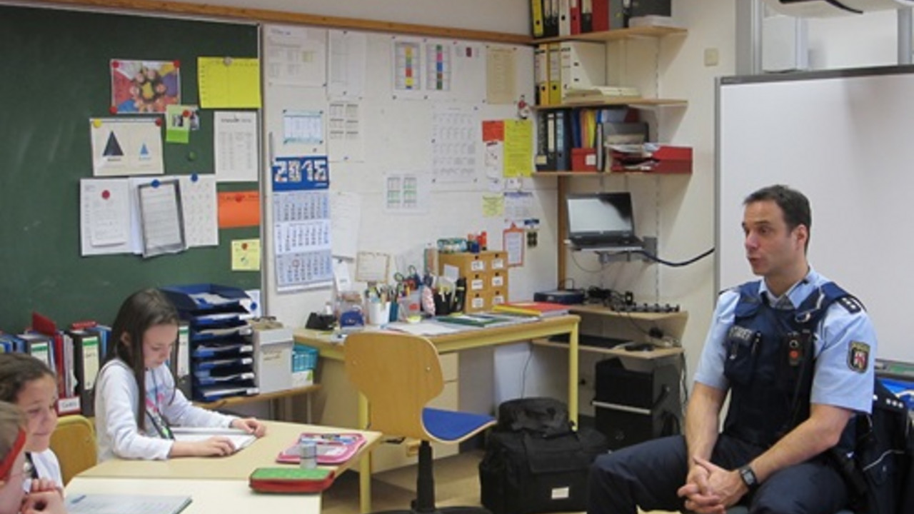 Herr Pitz und Schüler im Klassenraum. 