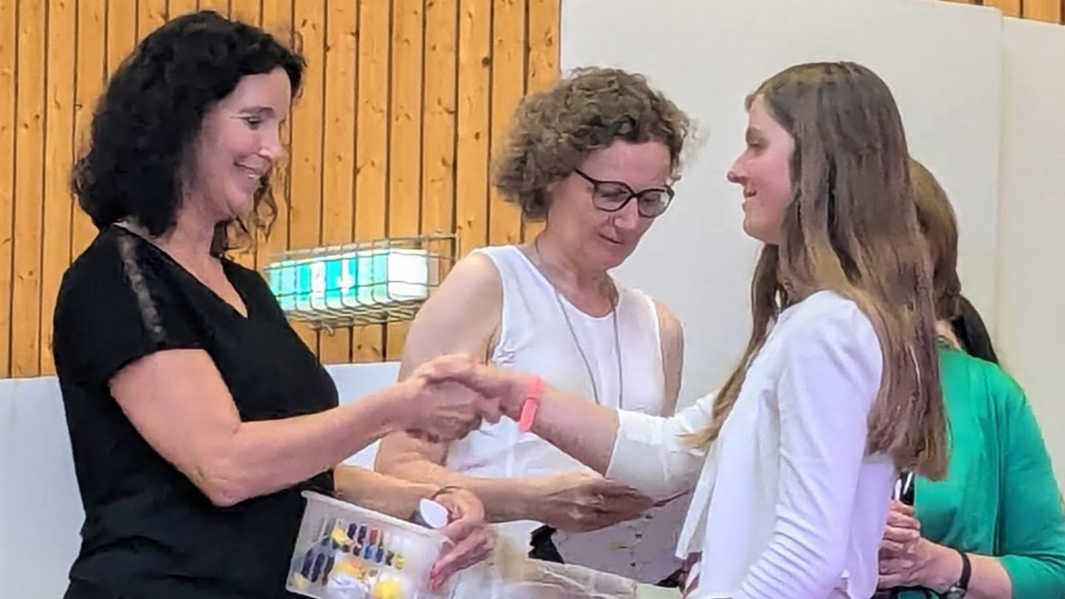 Die Klassenlehrerin und die Konrektorin gratulieren einer Entlassschülerin