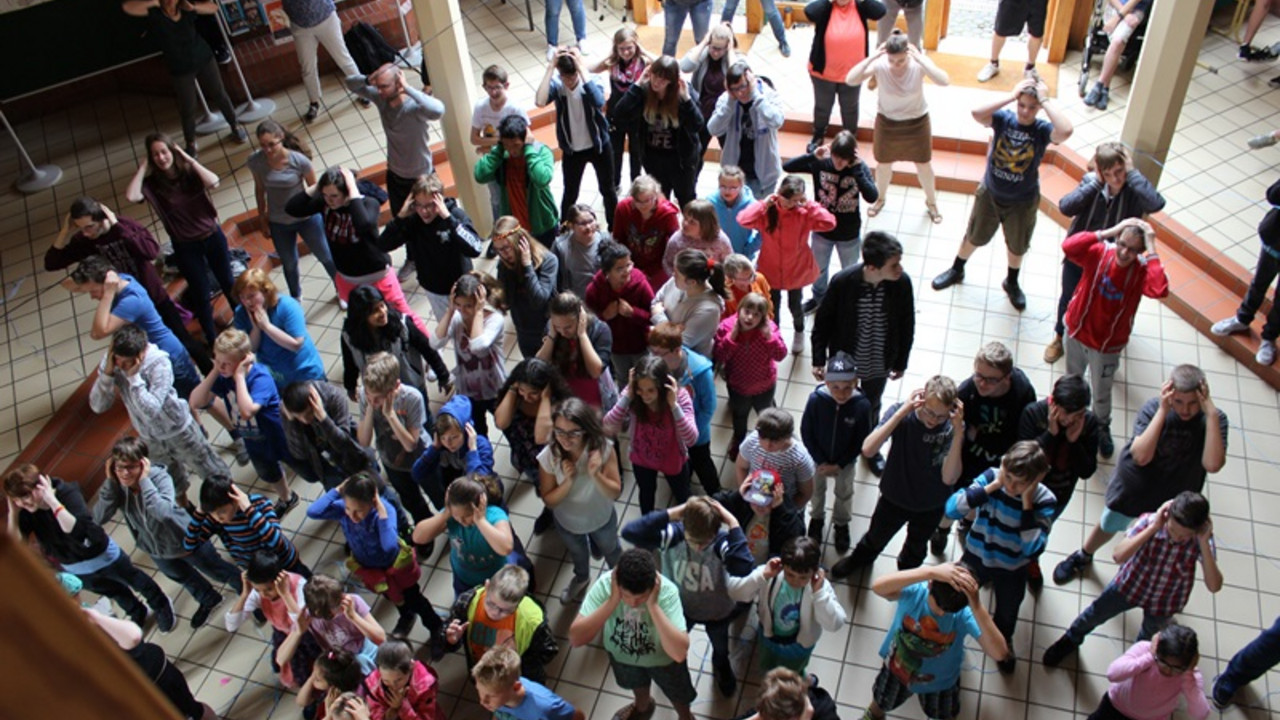 Schüler und Lehrer tanzen im Foyer