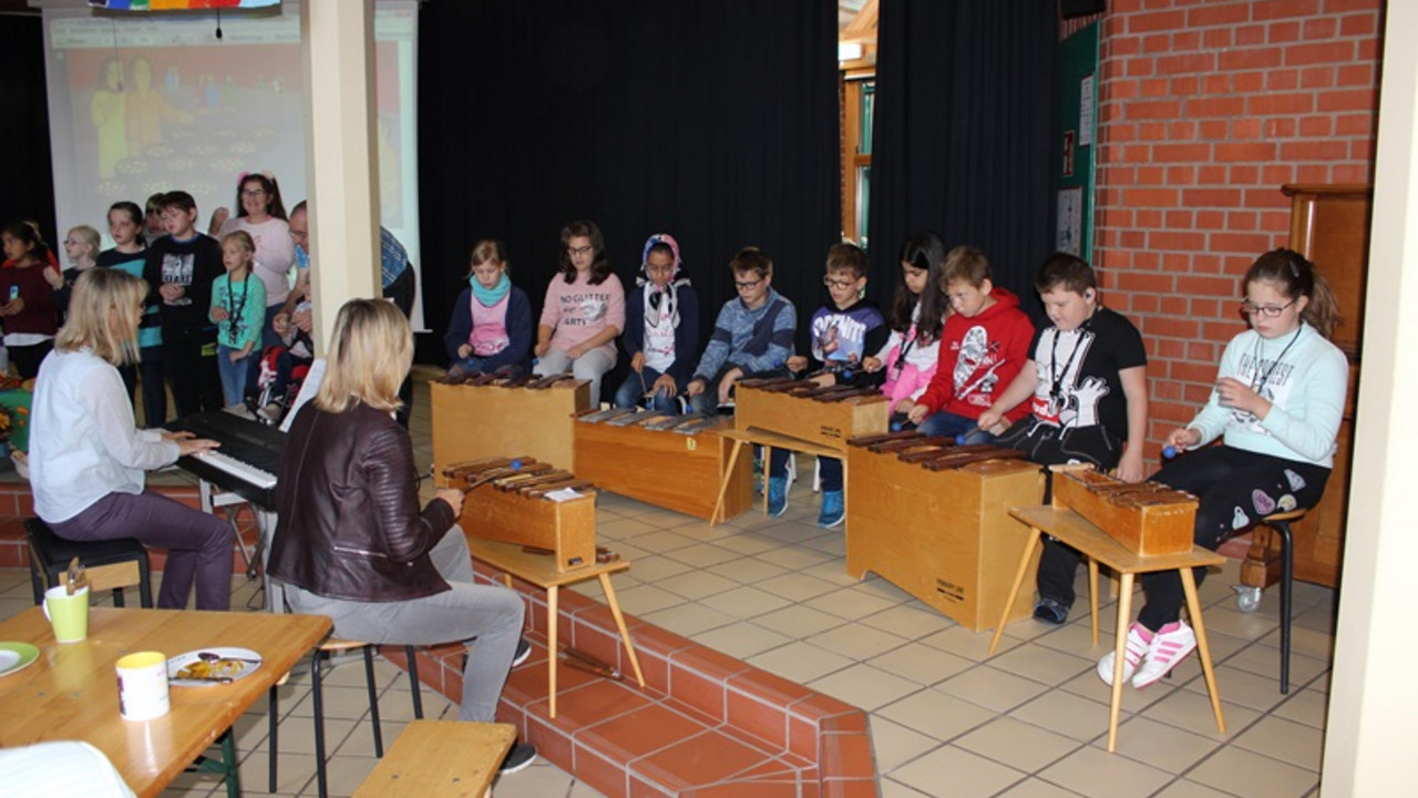 Lehrer und Schüler spielen Instrumente