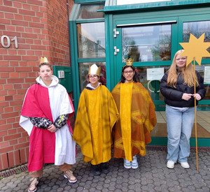 Sternsinger der GE OW in Verkleidung vor dem Schuleingang, Gruppenfoto