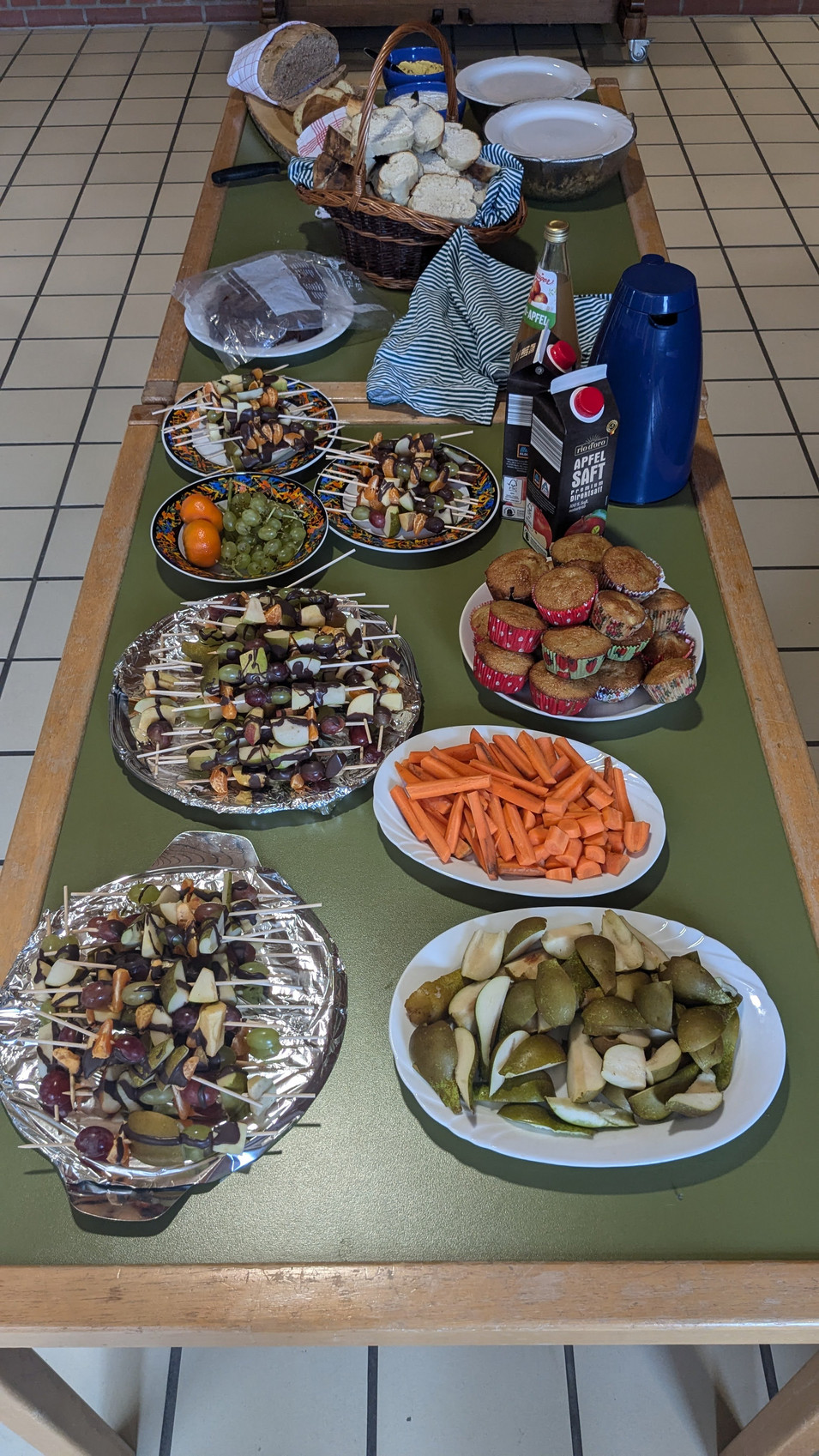 Großer Tisch mit den selbstgemachten Speisen, z.B. Obstspieße, Möhren und Birnen