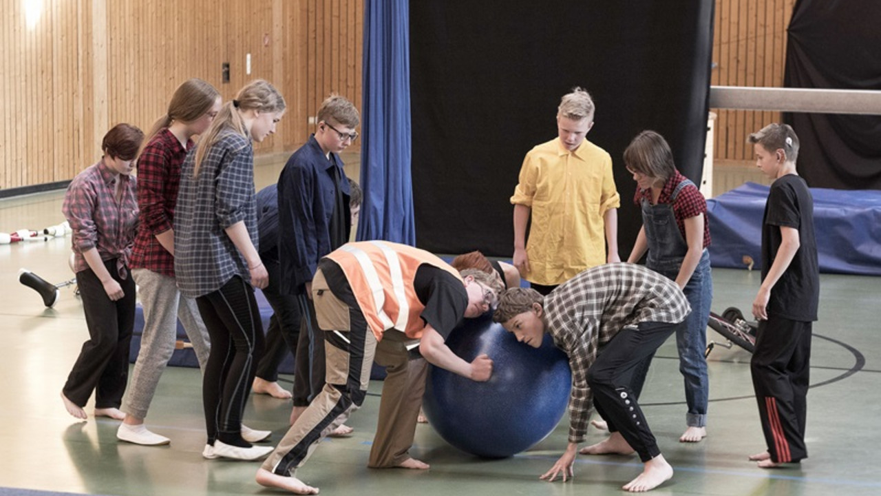 Schüler führen Kunststücke mit Gymnastikball auf. 