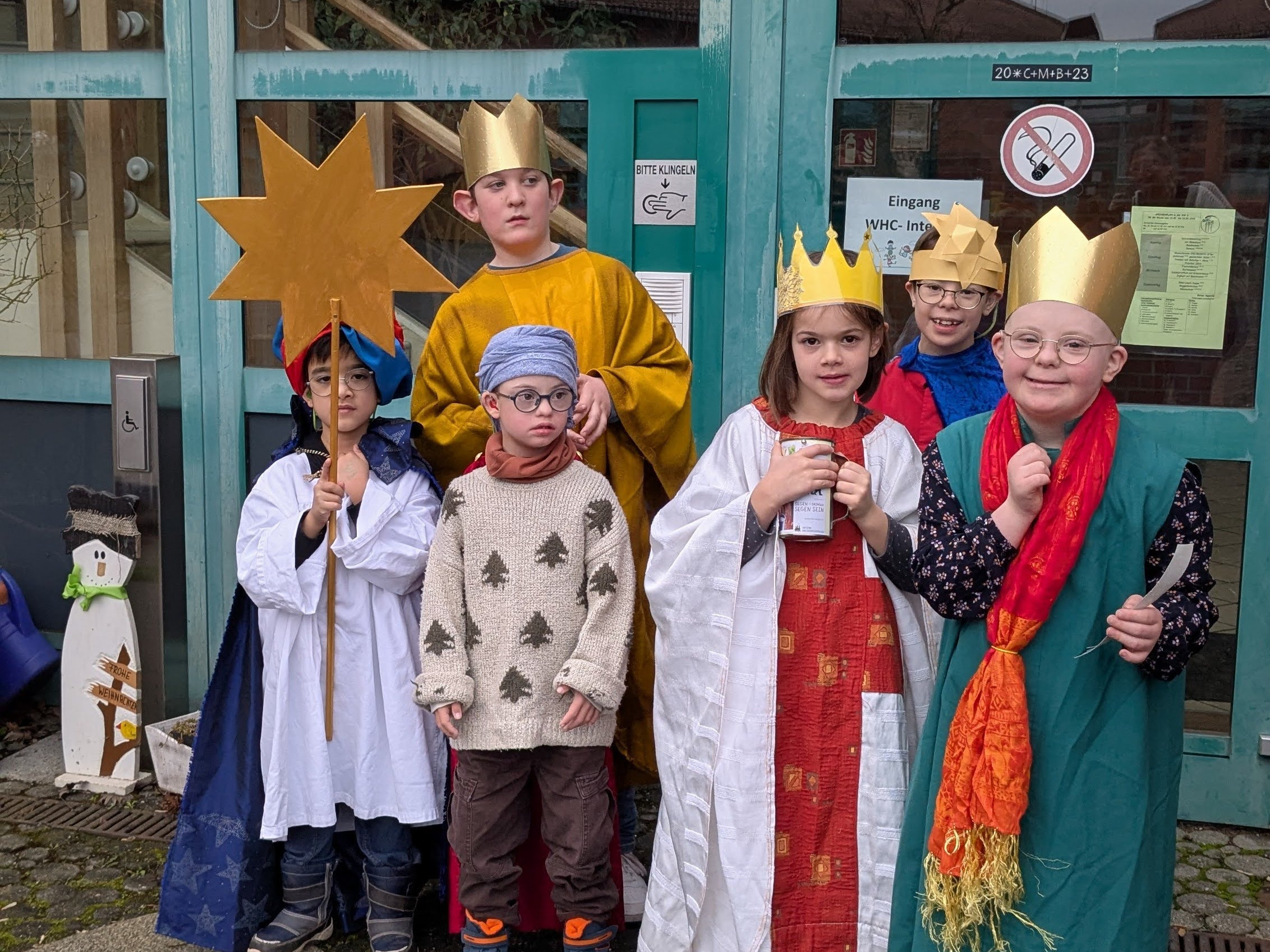 Die Sternsinger in Verkleidung vor dem Eingang der WHC.