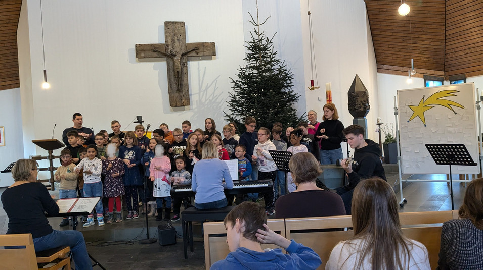 Schülerinnen und Schüler des Unterstufenchores singen und werden musikalisch von Schülern begleitet.