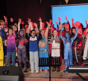 Der Unterstufenchor singt in Verkleidung auf der Bühne.