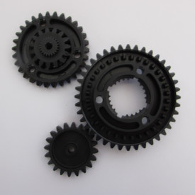 3 schwarze Plastikzahnräder aus einem Baukasten