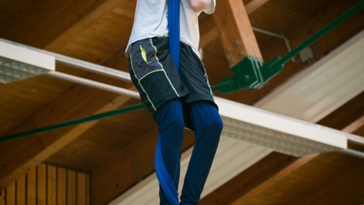 Schüler hängt im Vertikaltuch in der Luft