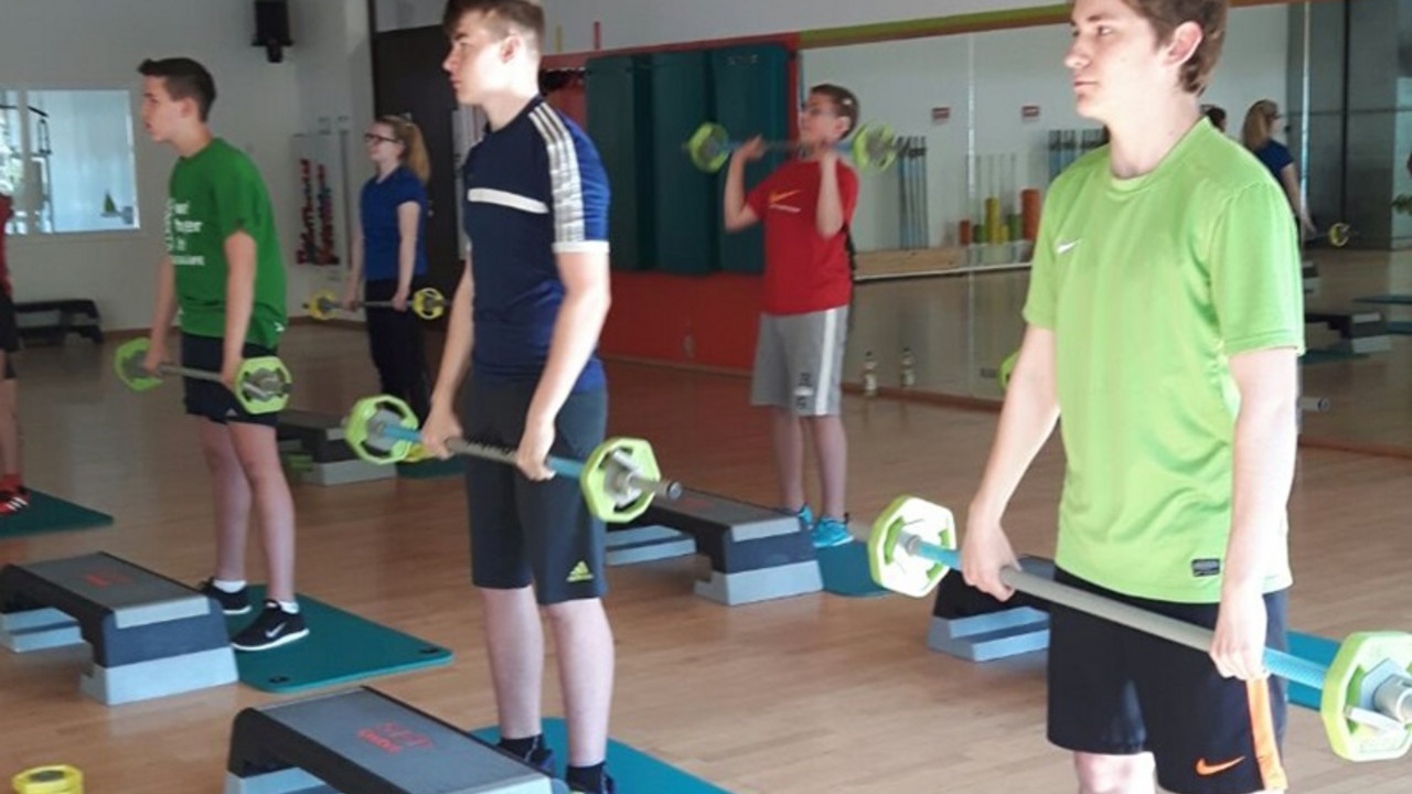 Kinder an Hanteln in Fitnessstudio