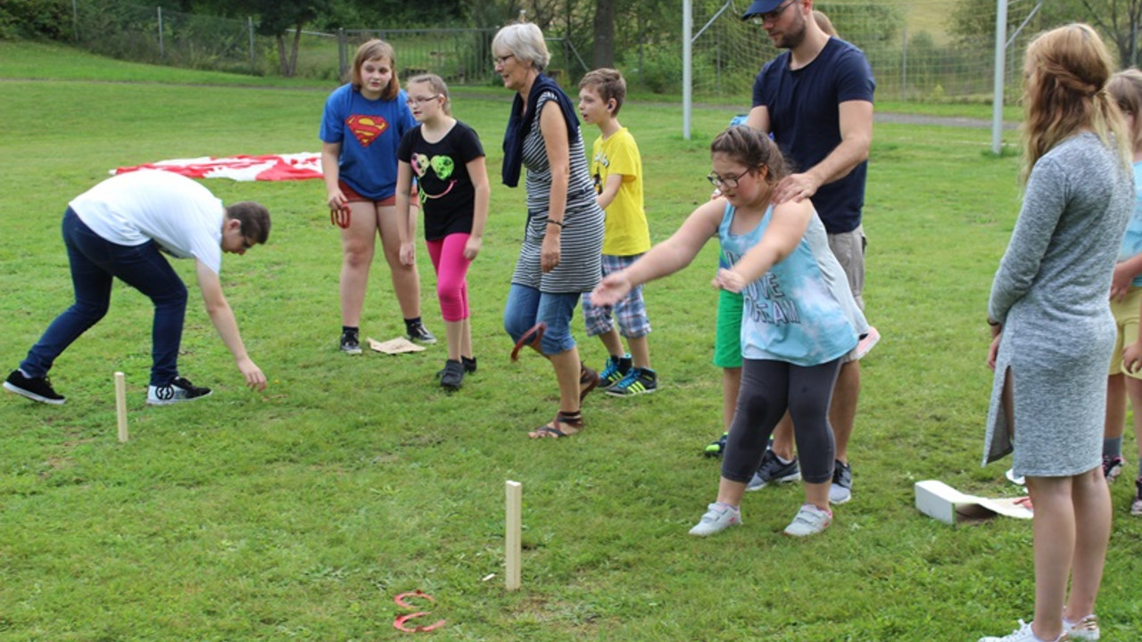 Kinder werfen Hufeisen auf ein Ziel