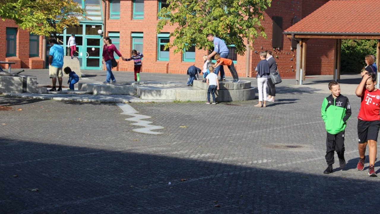 Eltern und Kinder spielen auf dem Schulhof 
