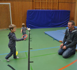 Vater mit Kindern in Turnhalle