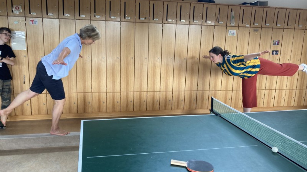 2 Lehrerinnen turnen im Lehrerzimmer. 