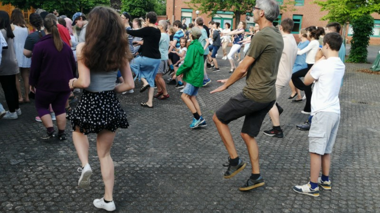 Alle tanzen auf dem Schulhof. 