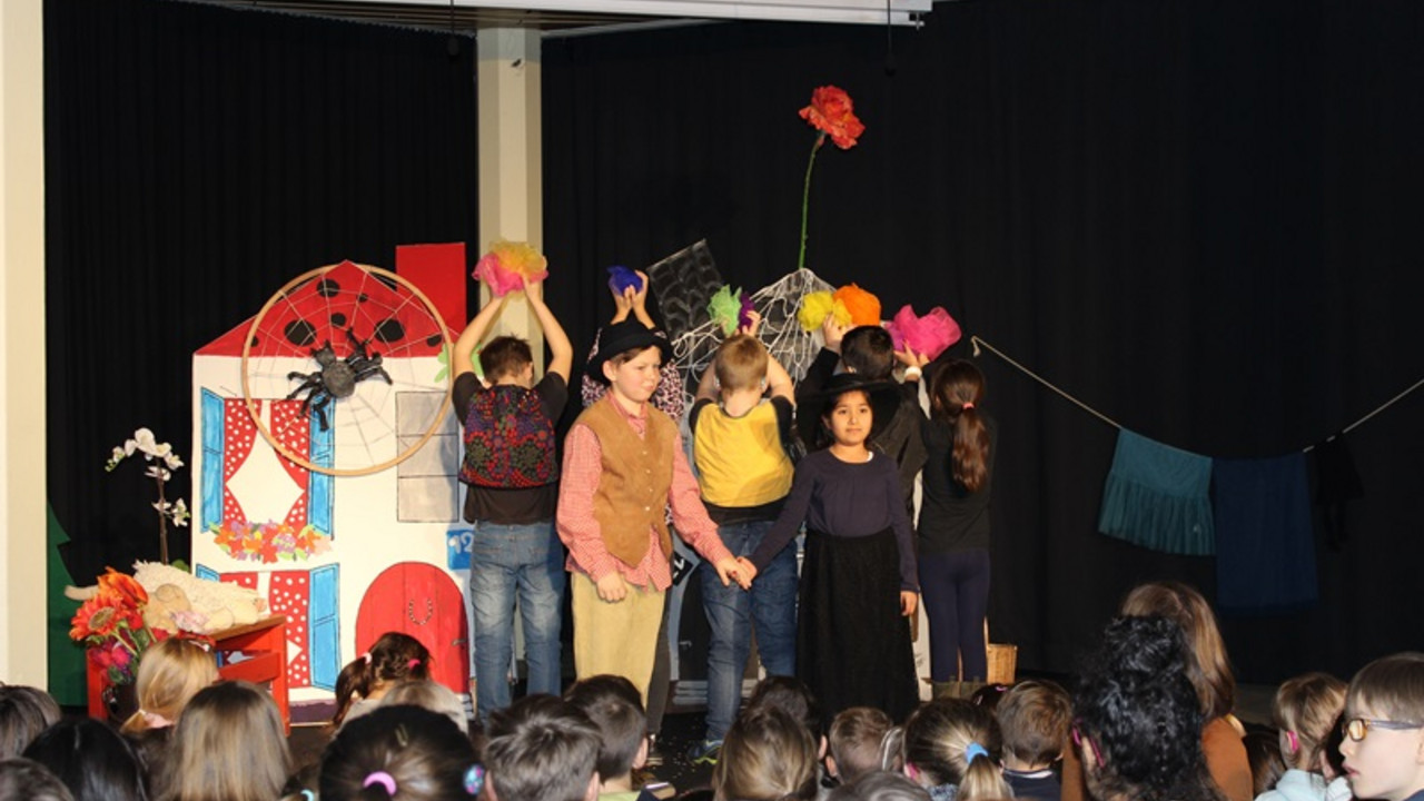Schülerinnen und Schüler stehen auf der Bühne