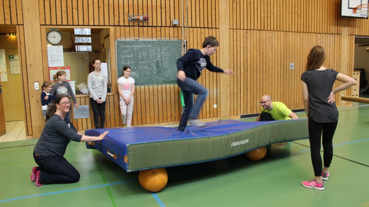 Kinder turnen in der Turnhalle.