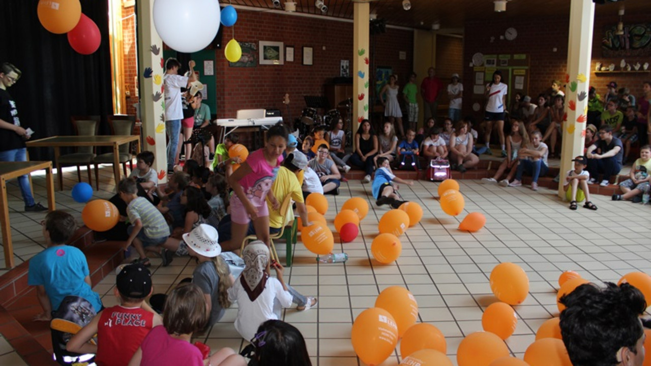 Schüler und Lehrer im Foyer mit Luftballons. 