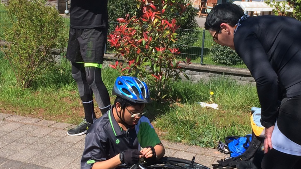 Schüler wechselt Reifen an Fahrrad.