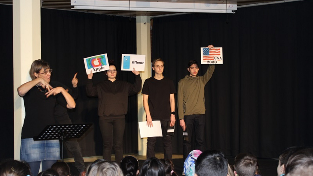 Schüler stehen auf der Bühne und spielen ein Stück vor