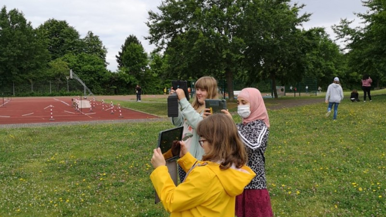 Schüler*innen fotografieren draußen