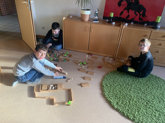 Kinder spielen auf dem Boden mit Bauklötzen. 